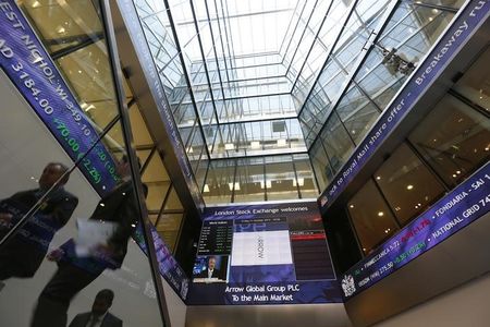 © Reuters. People pass electronic information boards at the London Stock Exchange in the City of London © Reuters. People pass electronic information boards at the London Stock Exchange in the City of London