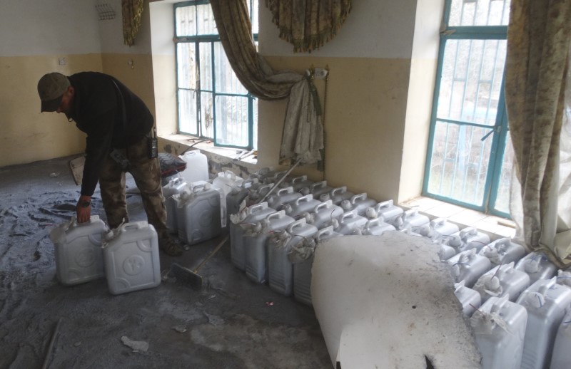 © Reuters. An Iraqi soldier stands next to bombs made using jerrycans at a Islamic State bomb factory in Jweba on the eastern fringes of Ramadi