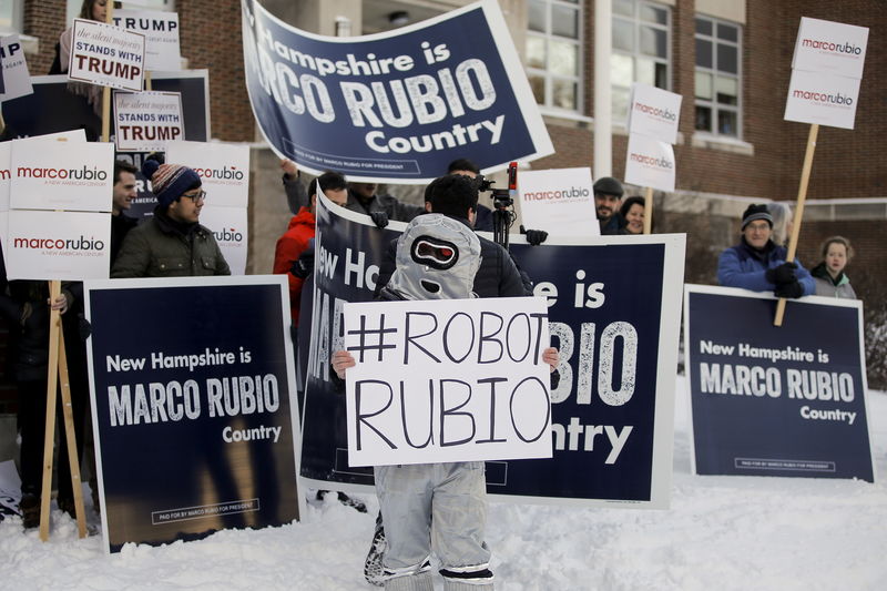 © Reuters. A man dressed as a robot stands outside a polling place as he waits for U.S. Republican presidential candidate Marco Rubio to arrive on voting day in Manchester, New Hampshire