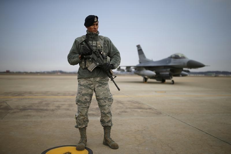 © Reuters. A U.S. soldier stands guard in front of their Air F-16 fighter jet at Osan Air Base in Pyeongtaek