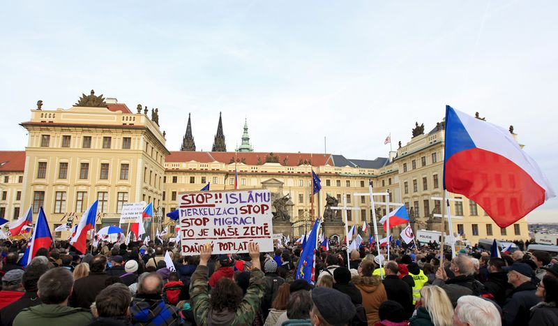 © Reuters. Demonstrators hold national flags and banners during an anti-immigrants rally in Prague