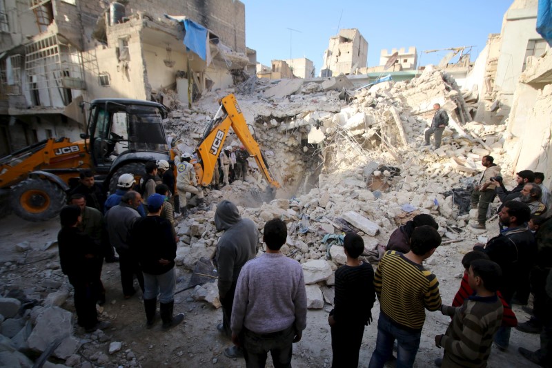 © Reuters. Civil defence members search for survivors after airstrikes by pro-Syrian government forces in the rebel held al-Qaterji neighbourhood of Aleppo