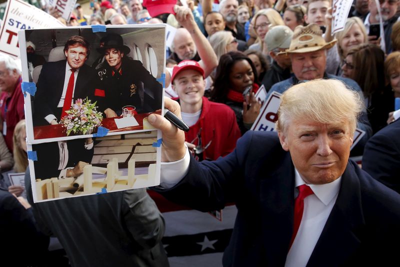 © Reuters. U.S. Republican presidential candidate Donald Trump holds up a photo of himself and late entertainer Michael Jackson that a memorabilia collector asked him to sign as he greets supporters after speaking at a rally with sportsmen in Walterboro